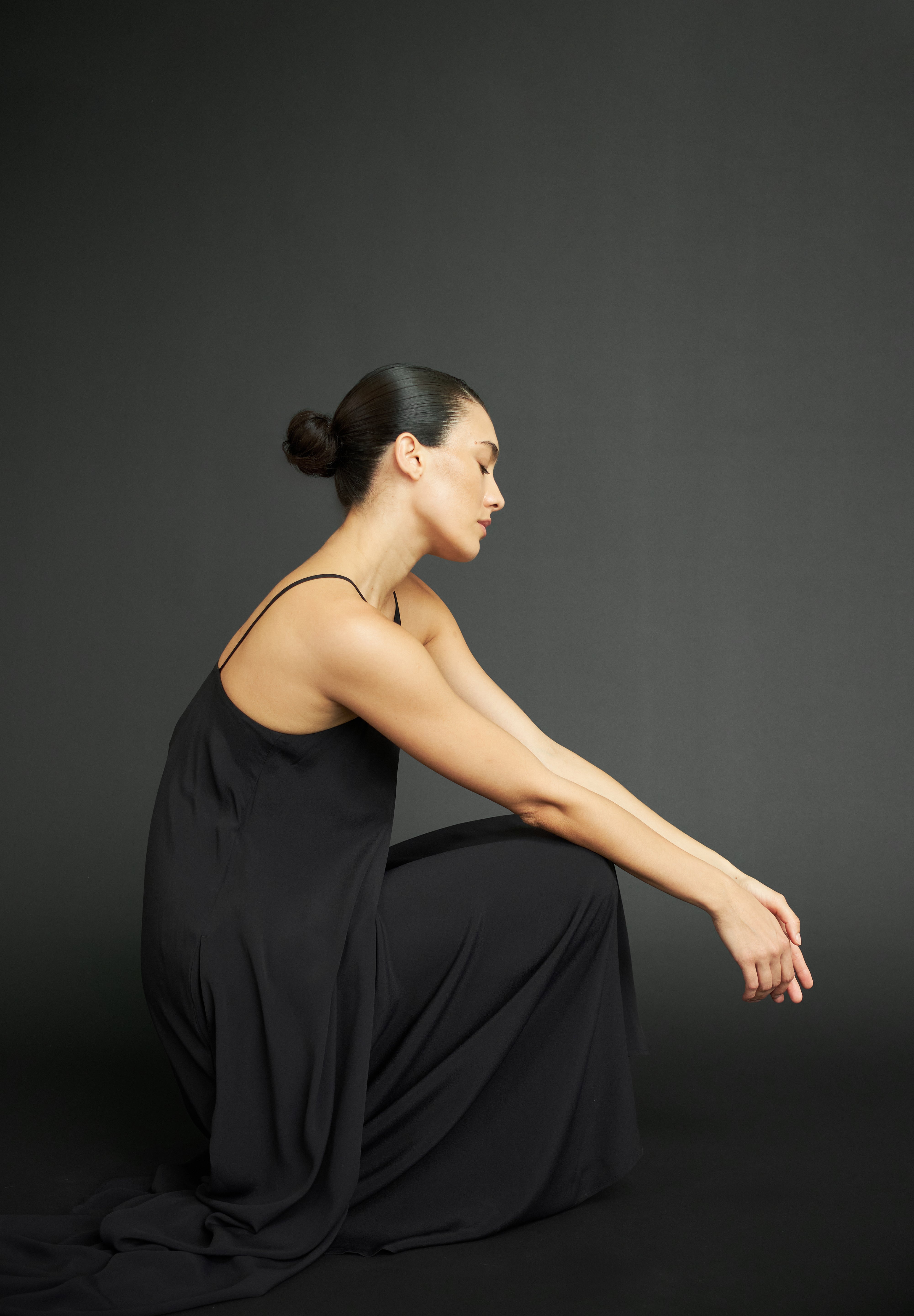 Woman with black dress in an relaxed crouched down posture